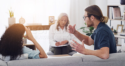 Buy stock photo Couple, therapist and argument on sofa, fight and consultation for mental health at wellness clinic. People, psychologist and writing notes on clipboard, stress or conflict resolution in relationship