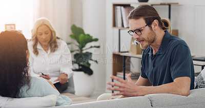 Buy stock photo Couple, therapist and fight on sofa, conflict and consultation for mental health at wellness clinic. People, psychologist and writing notes on clipboard, stress or argument in relationship counseling