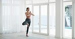 Woman, home and tree pose with prayer hands for exercise, yoga and balance by window for health. Female person, wellness and posture with namaste, mindfulness or fitness with zen in apartment
