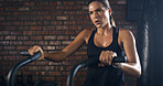 Athlete, woman and fitness with bicycle at gym for exercise, intense training and endurance. Female person, sweating and stationary bike for cardio workout, cycling performance and sports challenge