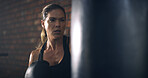 Woman, boxer and punching bag at gym with training, routine and intense workout for fitness. Person, athlete and exercise for martial arts, combat sports and power with equipment for fight at club