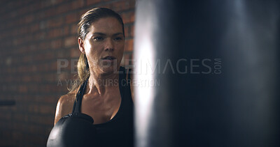 Buy stock photo Woman, boxer and punching bag at gym with training, routine and intense workout for fitness. Person, athlete and exercise for martial arts, combat sports and power with equipment for fight at club