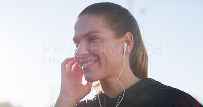 Buy stock photo Smile, earphones and runner with woman in city for workout playlist, streaming service and health. Exercise podcast, audio subscription and wellness radio with person and music outdoor space