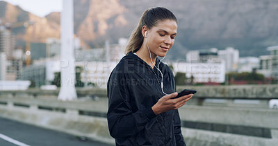 Buy stock photo Woman, runner and earphones with phone in city, streaming or training with music, stats or check timer. Person, smartphone and smile with audio subscription, scroll or fitness app on bridge in Mexico