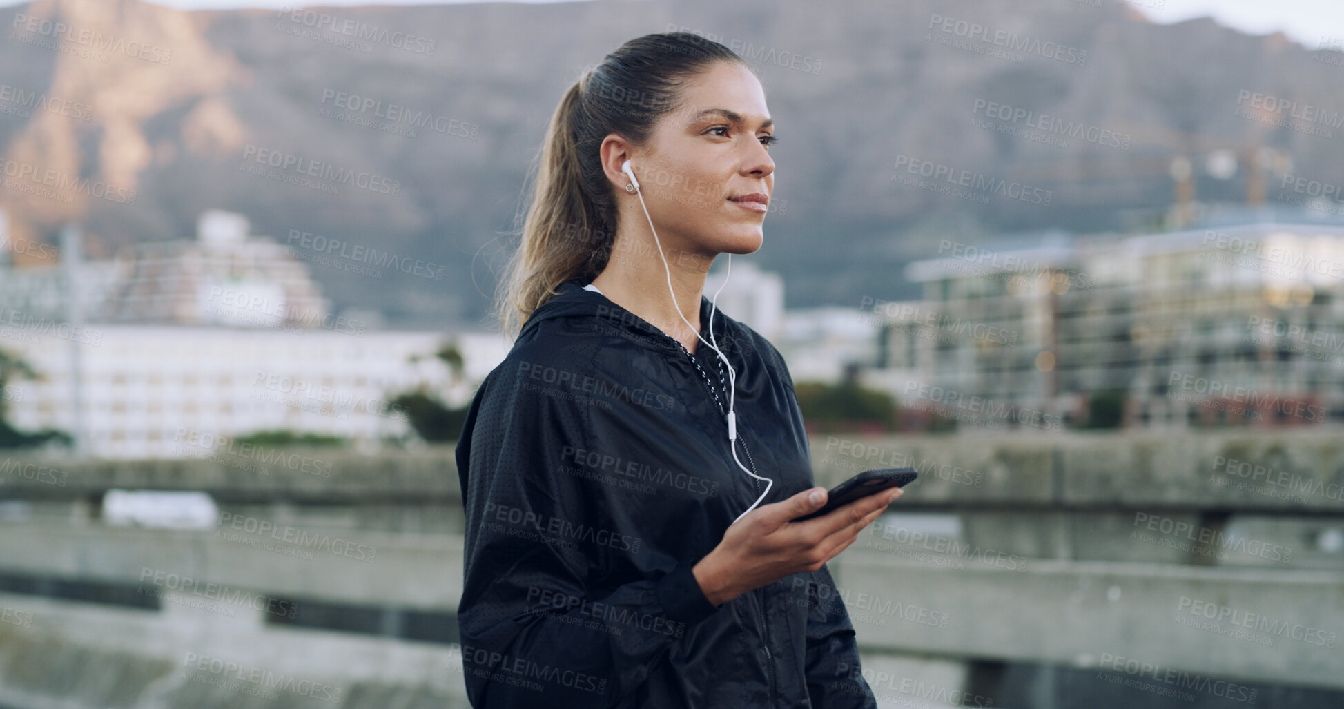 Buy stock photo Woman, runner and earphones with phone on bridge, streaming and training with music in urban town. Person, smartphone and audio subscription in city, perspective or fitness app on road in Mexico