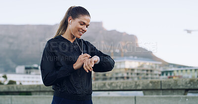 Buy stock photo Woman, runner and smile with smart watch in city with timer, stats or earphones for music with fitness. Person, stopwatch app and happy with training, results and streaming on bridge in South Africa
