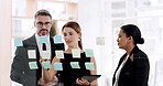 Business people, planning and writing with sticky notes for meeting or schedule tasks in office. Group, employees or taking notes with tablet for team strategy, ideas or brainstorming in workplace