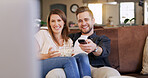 Popcorn, smile and couple on sofa in home with watching movie, series or show together. Happy, love and man with woman streaming film with snack in living room for date on weekend break in apartment.