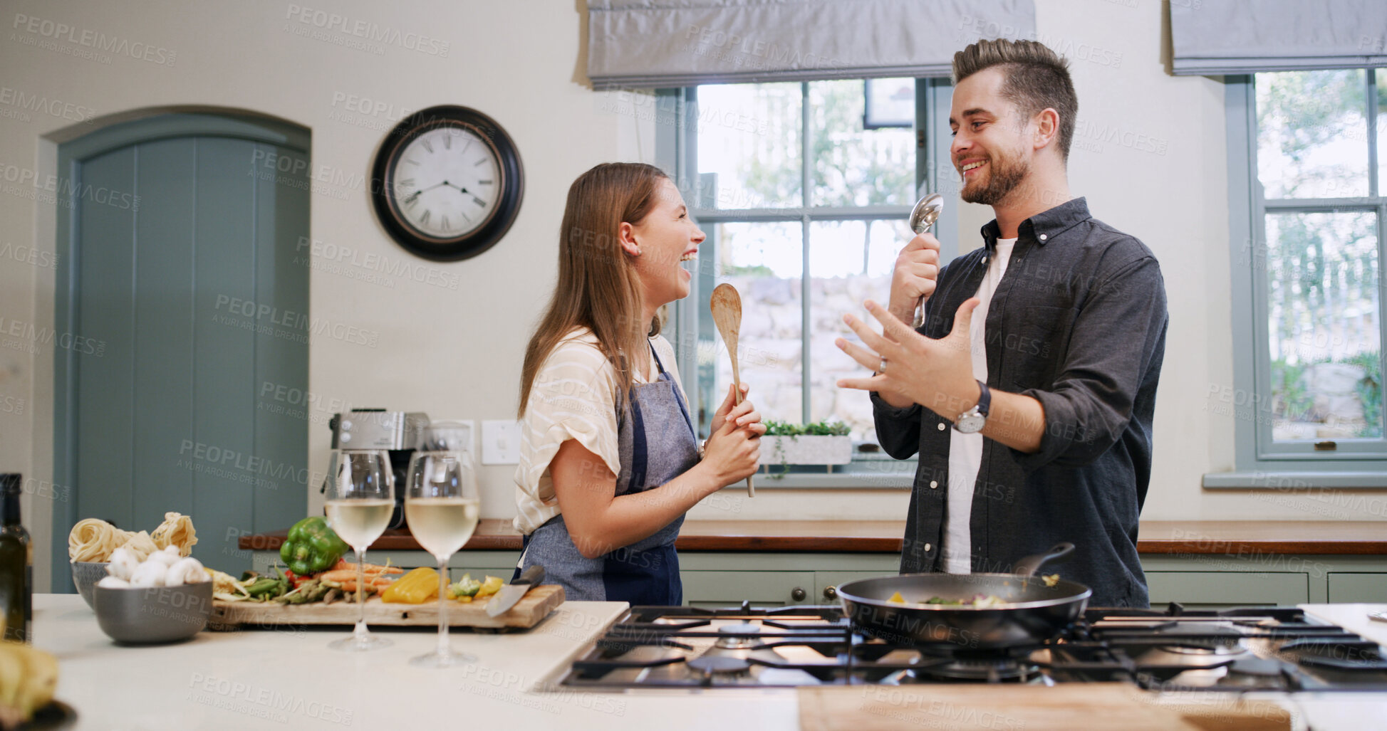 Buy stock photo Happy, couple and cooking with singing in home for dinner date, meal prep or anniversary track. Bonding, people and spoon with karaoke in kitchen for marriage song, music performance and lunch recipe