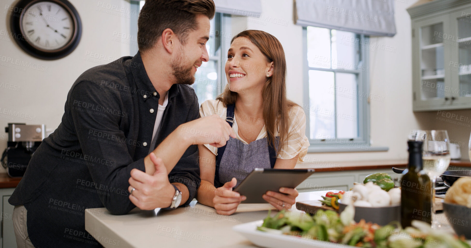 Buy stock photo Cooking, talking and couple with tablet in kitchen for dinner, supper and meal prep in home. Food, happy and man with woman on digital tech for online recipe, ingredients and culinary tutorial
