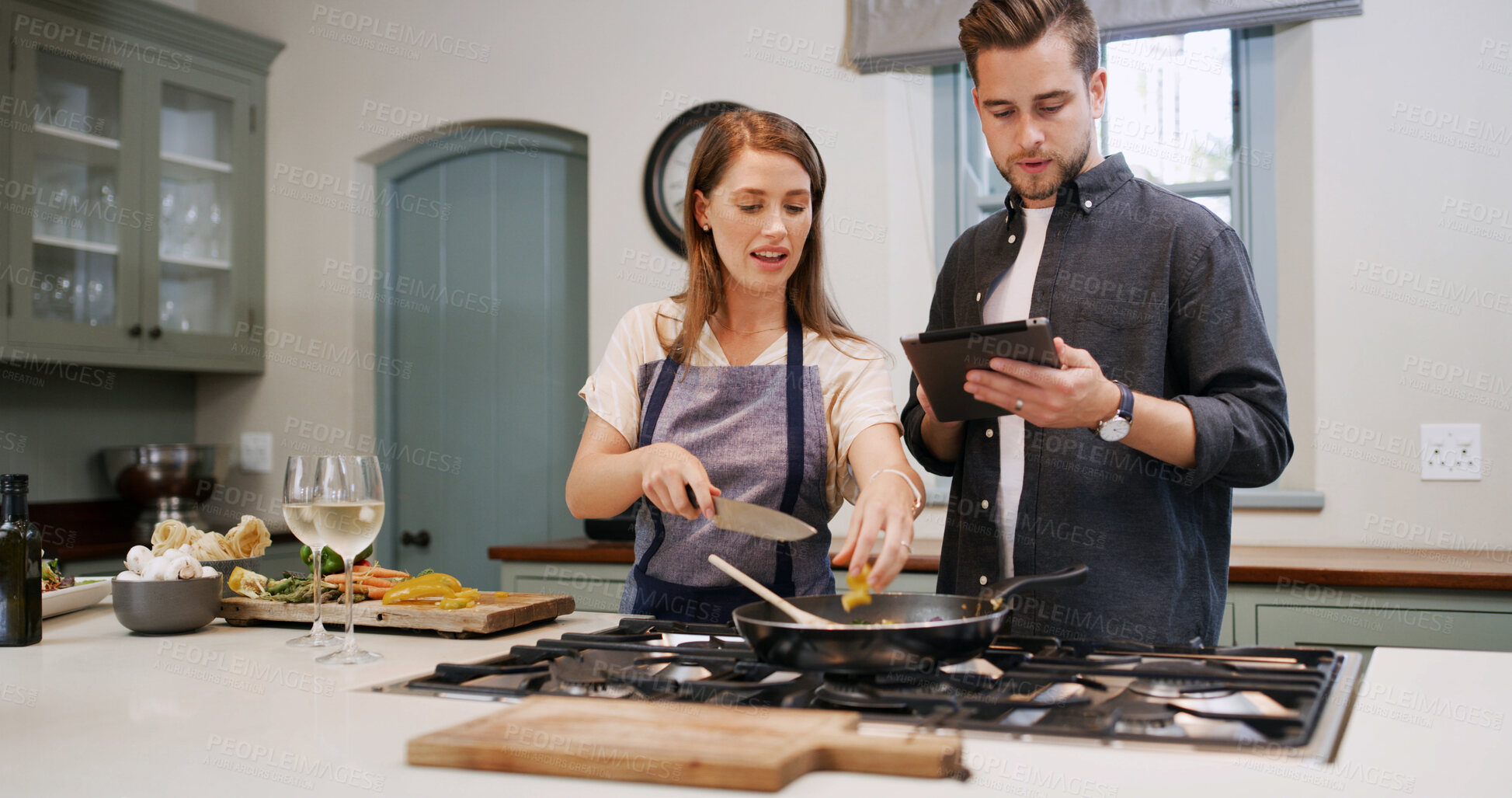 Buy stock photo Cooking, stove and couple with tablet in kitchen for dinner, supper and meal prep in home. Relationship, food and man with woman on digital tech for online recipe, ingredients and culinary tutorial