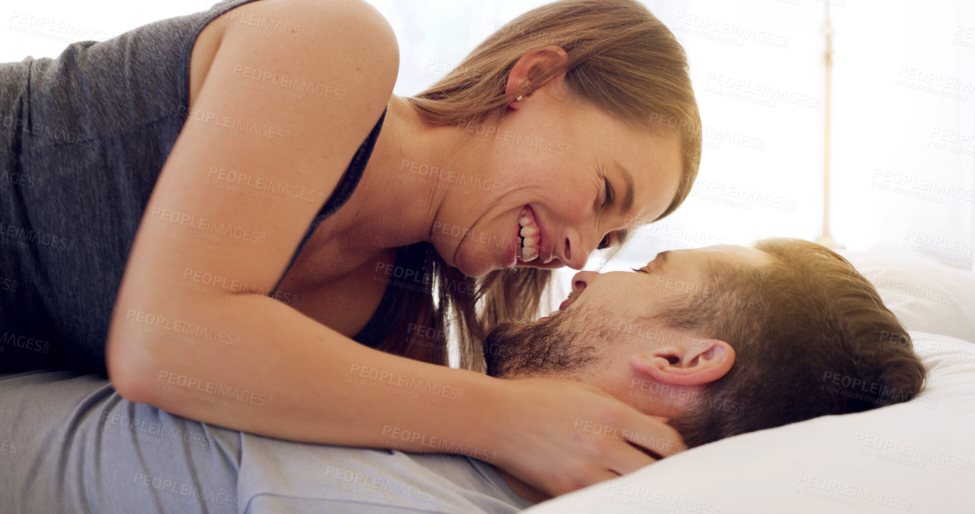Buy stock photo Happy, couple and relax with romance on bed for healthy relationship, weekend break and connection. Love, people and cuddle together in house with laughing, marriage commitment or wake up affection