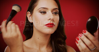 Buy stock photo Girl, makeup brush and mirror in studio for beauty with foundation, tools and lipstick on red background. Woman, cosmetics product and application with powder for transformation, skin and check face