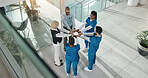 Hands together, doctors and people at hospital in circle with motivation for healthcare services. Above team, nurse and surgeon in group huddle with support, collaboration and meeting at clinic