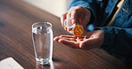 Water, pills and hands of man in house for medical treatment, prescription and tablets for recovery. Above, health and person with medication container for vitamins, supplements and drugs on table