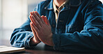 Documents, hands and prayer with person at desk in apartment for hope, opportunity or request. Guidance, job application and wish with man praying at table in home for career development or growth