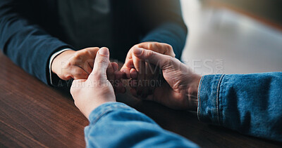 Buy stock photo Holding hands, table and couple in home for support, empathy and bonding for love. Relationship, counseling and above of people together for connection, affection and care for commitment in house