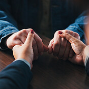 Holding hands, table and couple in home for comfort, empathy and ...