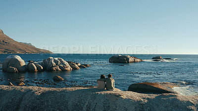 Buy stock photo Hug, horizon and back of couple by ocean for relaxing on holiday, vacation and weekend together. Dating, travel and man with woman embrace by sea, water and rocks for bonding, relationship or romance