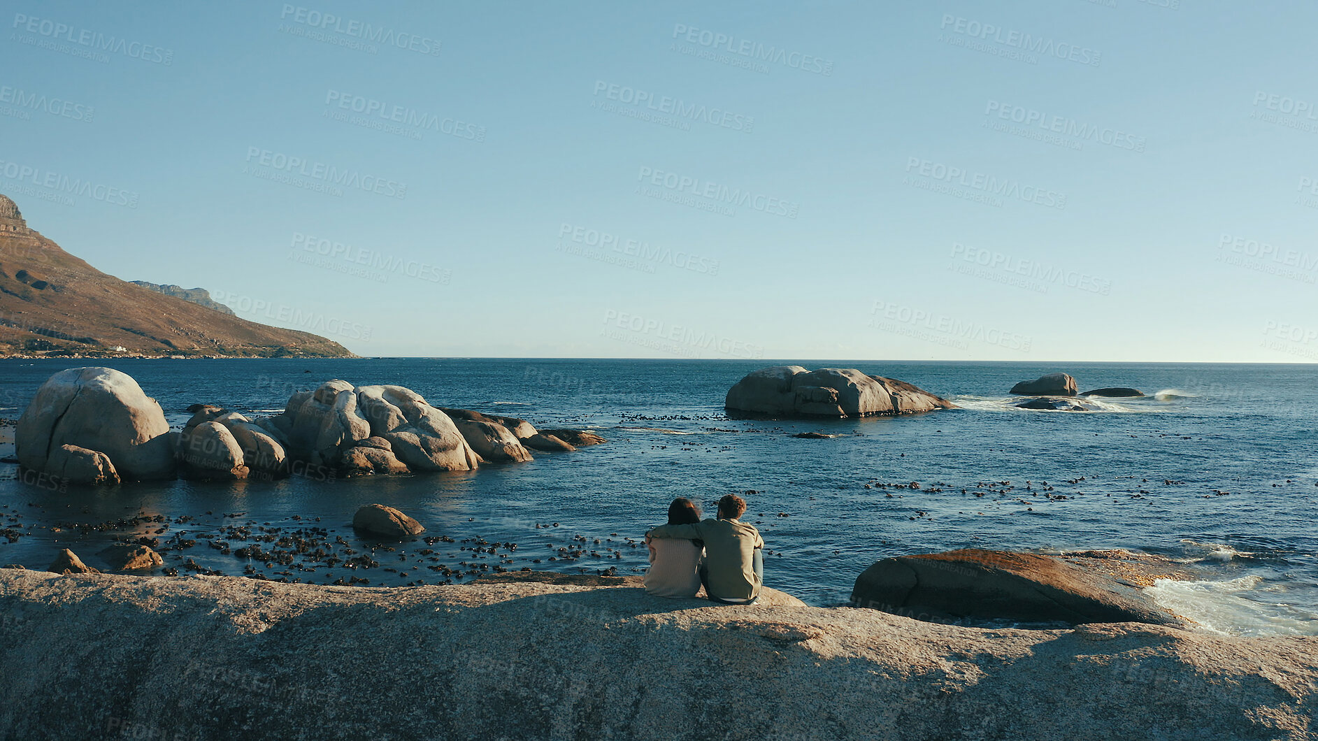 Buy stock photo Hug, horizon and back of couple by ocean for relaxing on holiday, vacation and weekend together. Dating, travel and man with woman embrace by sea, water and rocks for bonding, relationship or romance