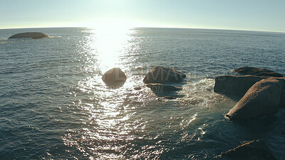 Buy stock photo Sunrise, waves and background of ocean with rocks for holiday destination, vacation and seascape. Sunlight, sea and horizon in natural environment with coastline scenery, beach ripples and landscape