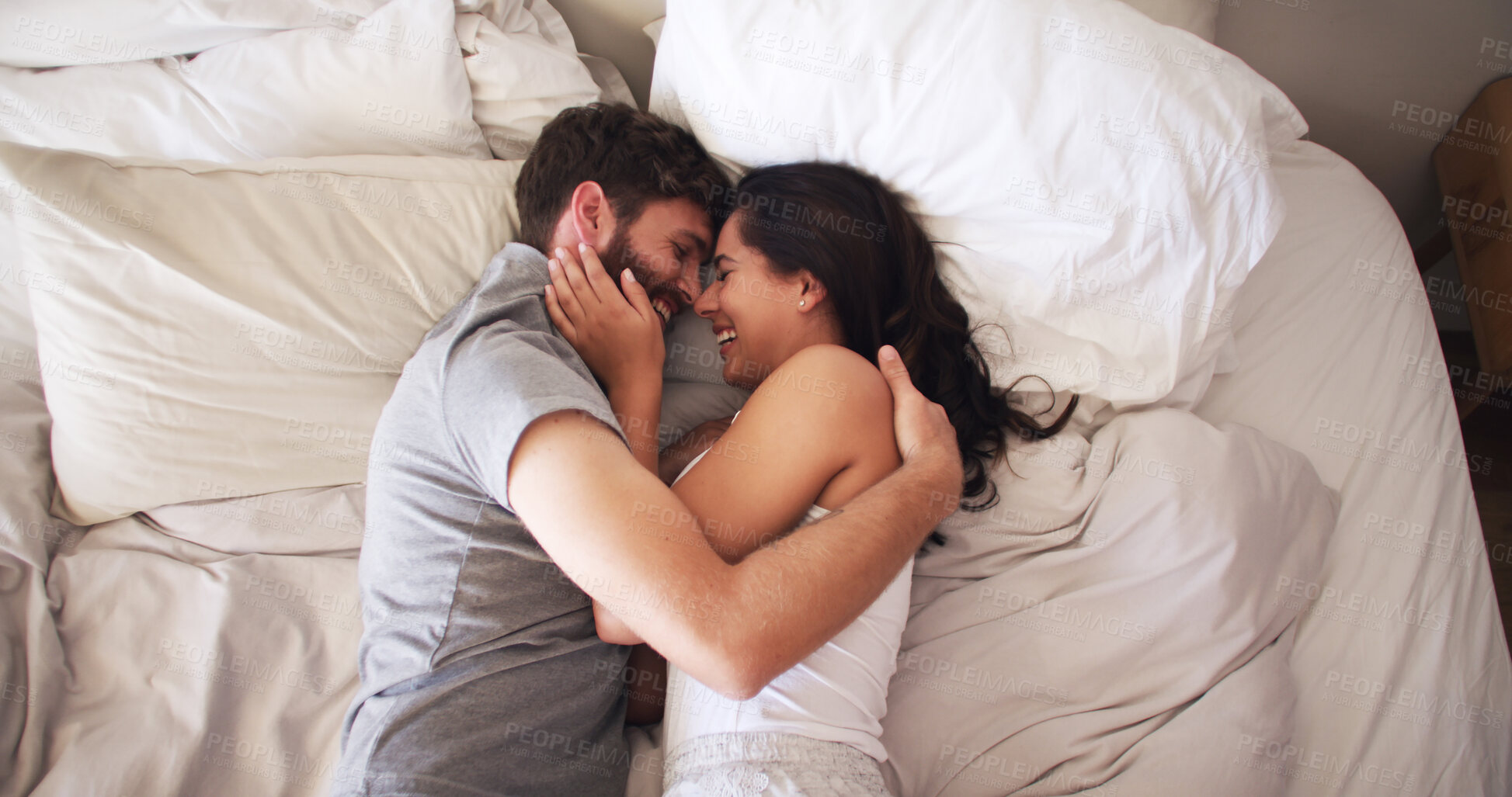 Buy stock photo Love, happy and couple with hug on bed for marriage commitment, bonding together or protection. Above, people and laugh with affection in bedroom for healthy relationship, funny joke or trust in home
