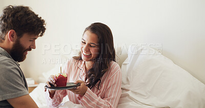 Buy stock photo Bedroom, cupcake and couple with smile, love and bonding together with candle, morning and dessert. Home, birthday and man with woman, snack and delicious with relationship, funny and celebration