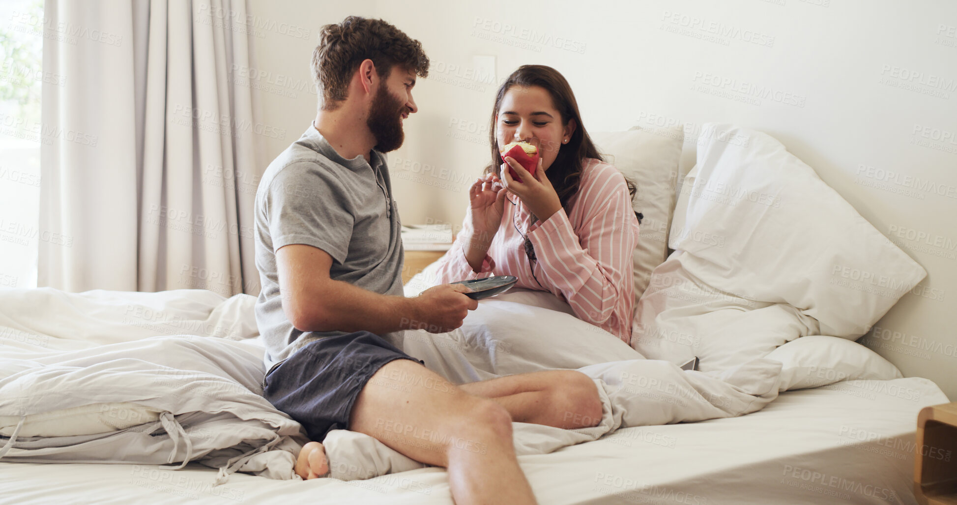 Buy stock photo Bedroom, cupcake and couple with love, eating and bonding together with happiness, marriage and care. Home, cake and man with woman, dessert and romantic with relationship, smile and morning
