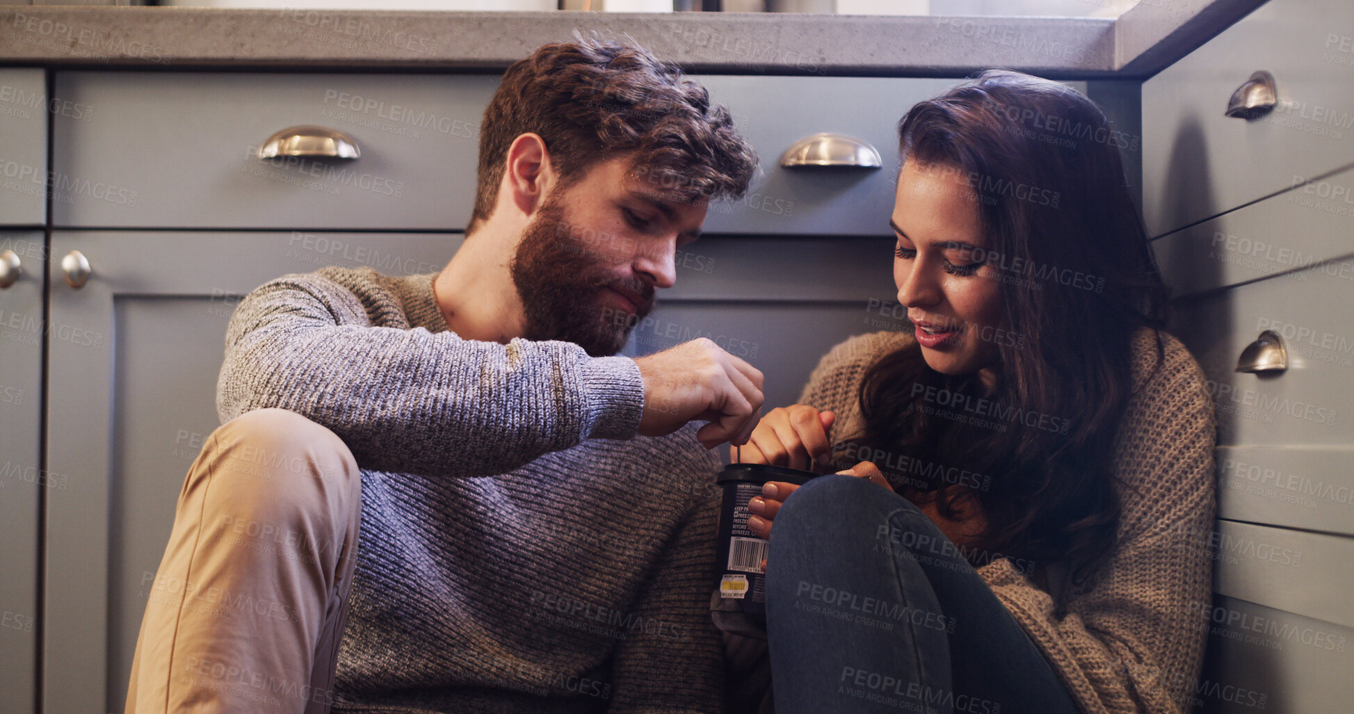 Buy stock photo Couple, relax and eating ice cream on floor with love, sharing dessert and bonding together. People, rest and partner with sweet treats of romantic date, frozen snack and marriage commitment at house