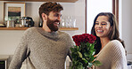 Flowers, romance and smile with couple in living room of home together for anniversary celebration. Bouquet of roses, gift giving or love with man and woman in apartment for bonding or security
