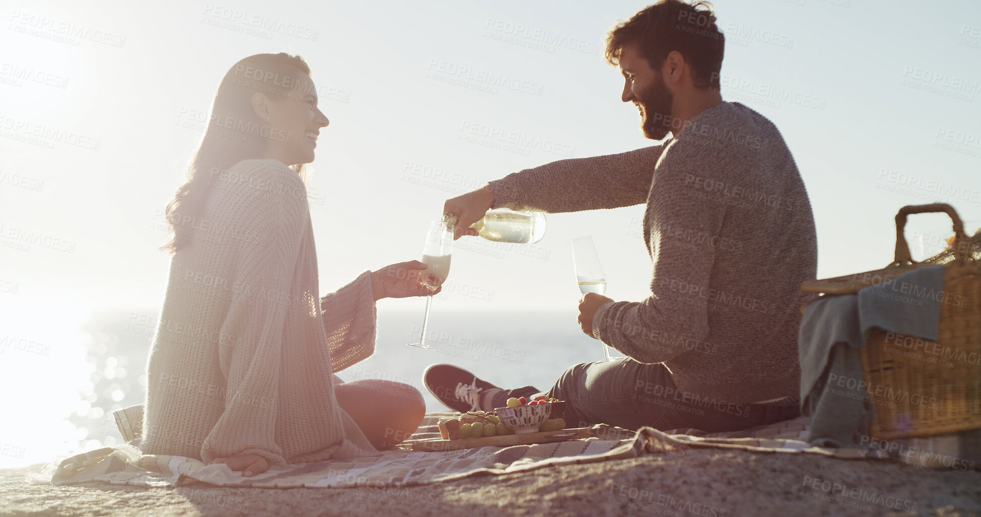 Buy stock photo Beach, picnic and couple with love, champagne and bonding together with vacation, relax and romance. Ocean, alcohol and man with woman, anniversary and celebration with summer holiday or relationship