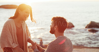Buy stock photo Happy woman, man and surprise with engagement ring at beach, propose and love at sunset on vacation. Couple, question and jewelry with wow, commitment or marriage offer by sea on holiday in Portugal