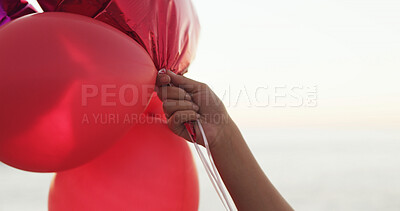Buy stock photo Hand, beach and balloons for love with valentines day celebration, holiday and space outdoor. Romantic gesture, inflatable and person at ocean for care, gift or present on vacation by sea for travel