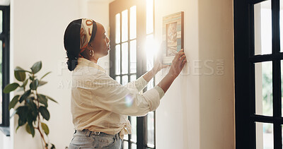Buy stock photo Art, woman and frame on wall in home for lounge decoration, interior design and aesthetic. Apartment, black person and hang picture in living room to display memory, creative remodeling and makeover