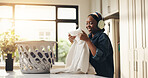 Home, woman and chores with headphones, laundry and smile for clean fabric, song or streaming music. Happy, black person and listening with tech, housework or basket with clothes in kitchen or house