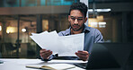 Business, man or serious with paperwork in office for financial review, invoices or compliance risk. Bookkeeper, worried person and laptop with statements for budget forecasting, bankruptcy and night