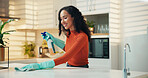 Smile, cleaning and spray with woman in kitchen for germ disinfection, chemical and housekeeping. Bacteria prevention, table hygiene and cloth with person in home for domestic chores and safety