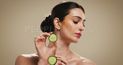 Buy stock photo Cucumber, skincare and beauty with woman in studio for organic cosmetics, hydration benefits and glow. Natural product, self care and antioxidant with person on brown background for shine and space