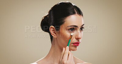 Buy stock photo Makeup brush, beauty and woman with concealer for glow, aesthetic or shine. Apply cosmetics, model and tools for foundation, product and facial transformation process on brown studio background space