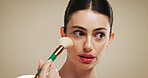 Beauty, foundation and brush with woman in studio for blush, cosmetics and makeup application. Contour tools, powder and cosmetology with person on background for glow, self care and shine space