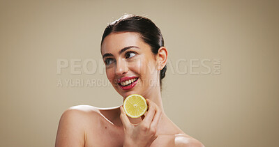 Buy stock photo Lemon, skincare and beauty with woman in studio for organic cosmetics, vitamin C benefits and glow. Natural product, self care or antioxidant with person on brown background for shine, fruit or space