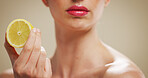 Lemon, skincare and lips of woman in studio for organic cosmetics, vitamin c benefits and glow. Natural product, self care and antioxidant with person on background for shine, fruit and beauty