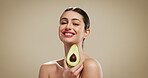 Woman, avocado and beauty studio portrait with smile, makeup or pride with mockup space on background. Girl, happy and confident with sustainable cosmetics, fruit and results with wellness in Turkey