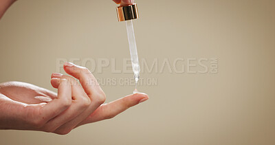 Buy stock photo Skincare, serum and hands of person in studio for hyaluronic acid, beauty and anti aging. Mockup space, dermatology and finger with dropper for cosmetics, collagen and retinol on brown background