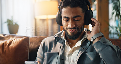 Buy stock photo Relax, man and phone with headphones on sofa for streaming playlist, audio subscription or song. Podcast, person and happy with smartphone in house for listening to album sound and feel good track