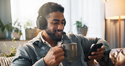 Buy stock photo Coffee, man and phone with headphones on sofa streaming music, audio subscription or online video. Smile, person and relax with smartphone in home for listening to album track, radio playlist or song