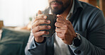 Coffee, hands and man on sofa in house with calm, peace or morning break with warm beverage. Espresso, relax and male person drinking cappuccino, latte or tea for wellness in living room at apartment