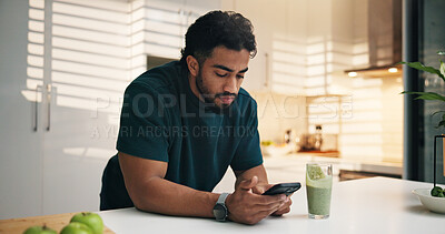 Buy stock photo Phone, smoothie and man in kitchen in morning with networking, communication or mobile app. Technology, health drink and male person with cellphone for texting, contact or social media in apartment.