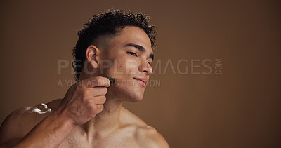 Buy stock photo Face, massage and man in studio with gua sha for natural skincare, lymphatic drainage and space. Person, mockup and jade stone for skin tightening, blood circulation and dermatology on background