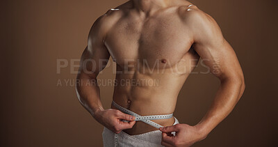 Buy stock photo Bodybuilder, lose weight and measuring waist, hands and tape to track progress, healthy and fitness. Studio background, shirtless and checking body results, muscle and person with biceps or wellness